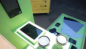 A picture from a top showing a tablet and a shirt | EcoDesign Circle | Interreg Baltic Sea Region | Designed like a wardrobe, the box ‘Dressing Wearing’ offers to visitors ‘Pure Waste Textiles’ from Finland made of 100% recycled cotton. And for enterprises interested in making use of excess materials from textiles production, the ‘Upmade software’ developed in Estonia is be of great interest. (© IDZ | International Design Centre Berlin)