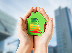 Pair of hands holding a green house showing the green to red colored energy saving level arrows A to G | ACT Now - a project of Interreg Baltic Sea Region (photo: Panthermedia/Lev Dolgachov)