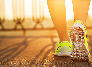 Close up of jogger's feet from behind walking on a paved road  | BaltCity Prevention - a project of Interreg Baltic Sea Region (photo: Panthermedia/Allllex)