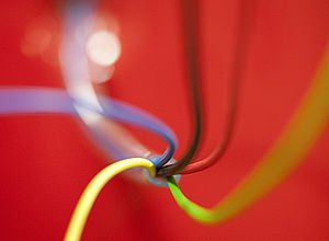 cable of five colored wires on red background | EmpInno - a project of Interreg Baltic Sea Region (photo: Kujawsko Pomorskie Innovation Agency)