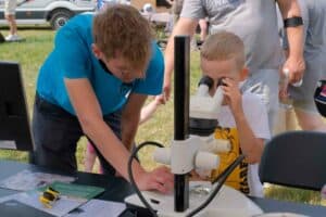 Girl looking a sample through microscope at The Tractor Day