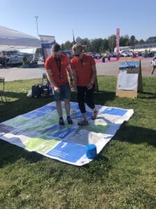 People standing on and playing large water protection board game.