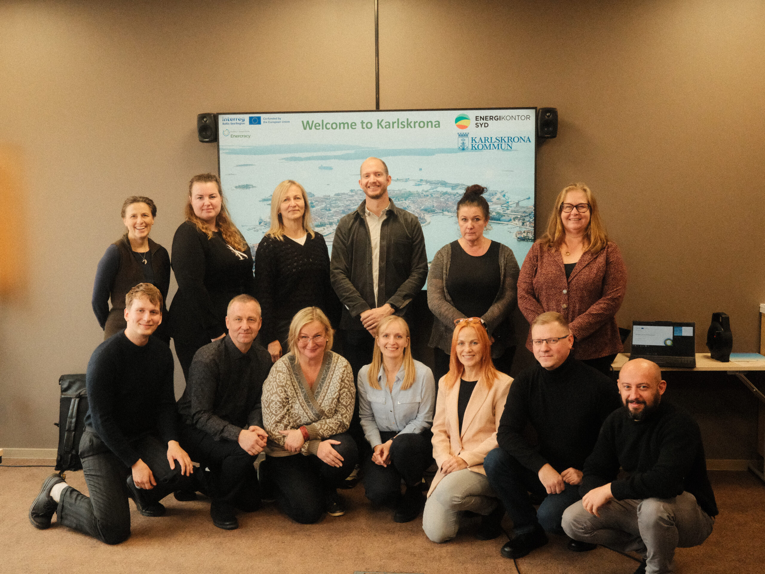 The group picture of the project consortium next to the screen.