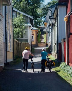 Two women with bicycles on the streets of Naantali
