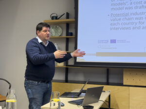 Danish professor Michal Beliatis is presenting in front of the screen.