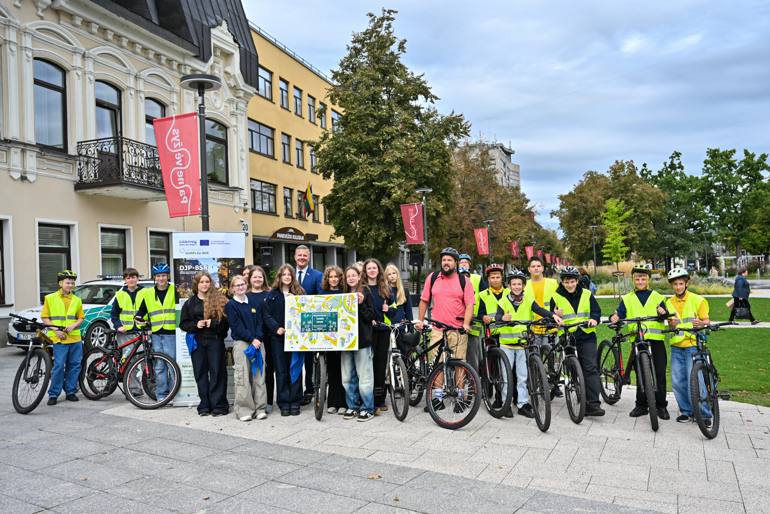Students and teachers standing with bikes and holding a plaque.