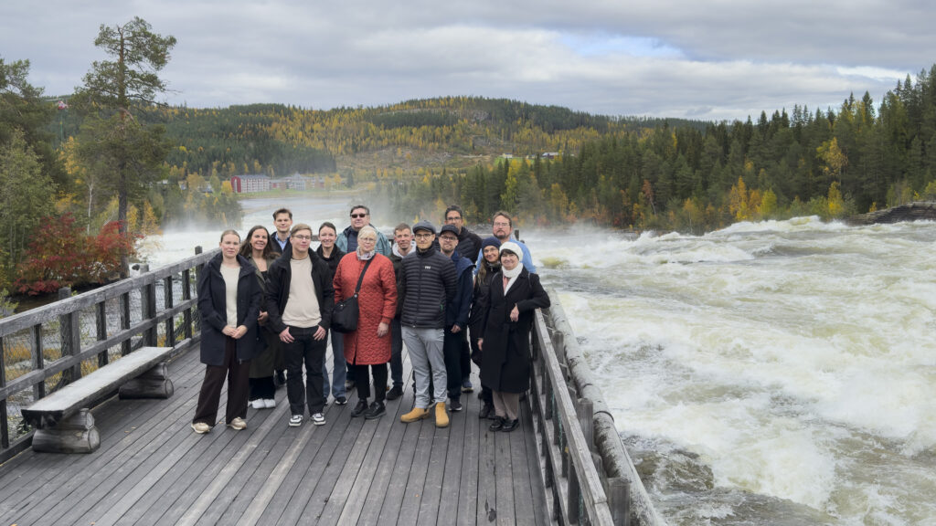 Group photo of 20 people in front of a big river